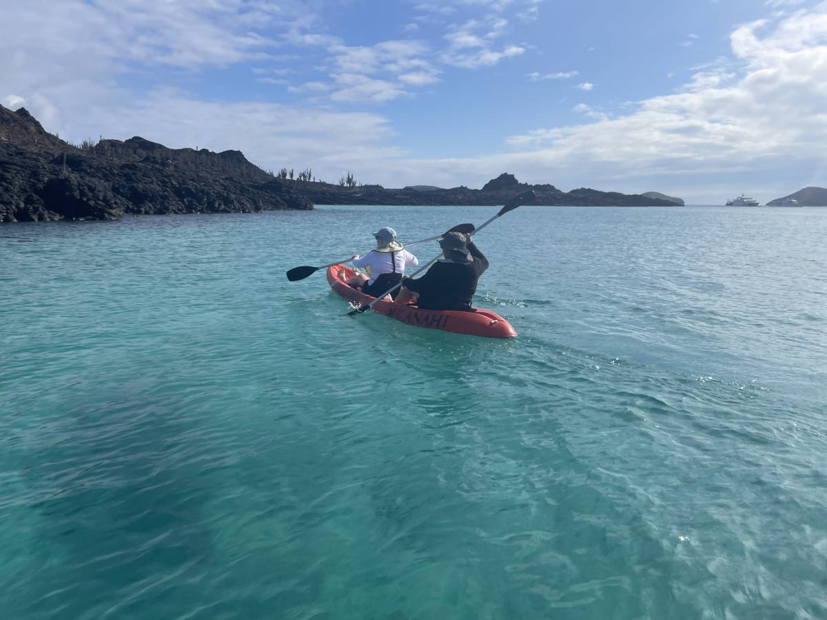 Kayaking in turquoise water near the Yate Anahi during a Galapagos Islands tour with Cultured Travel