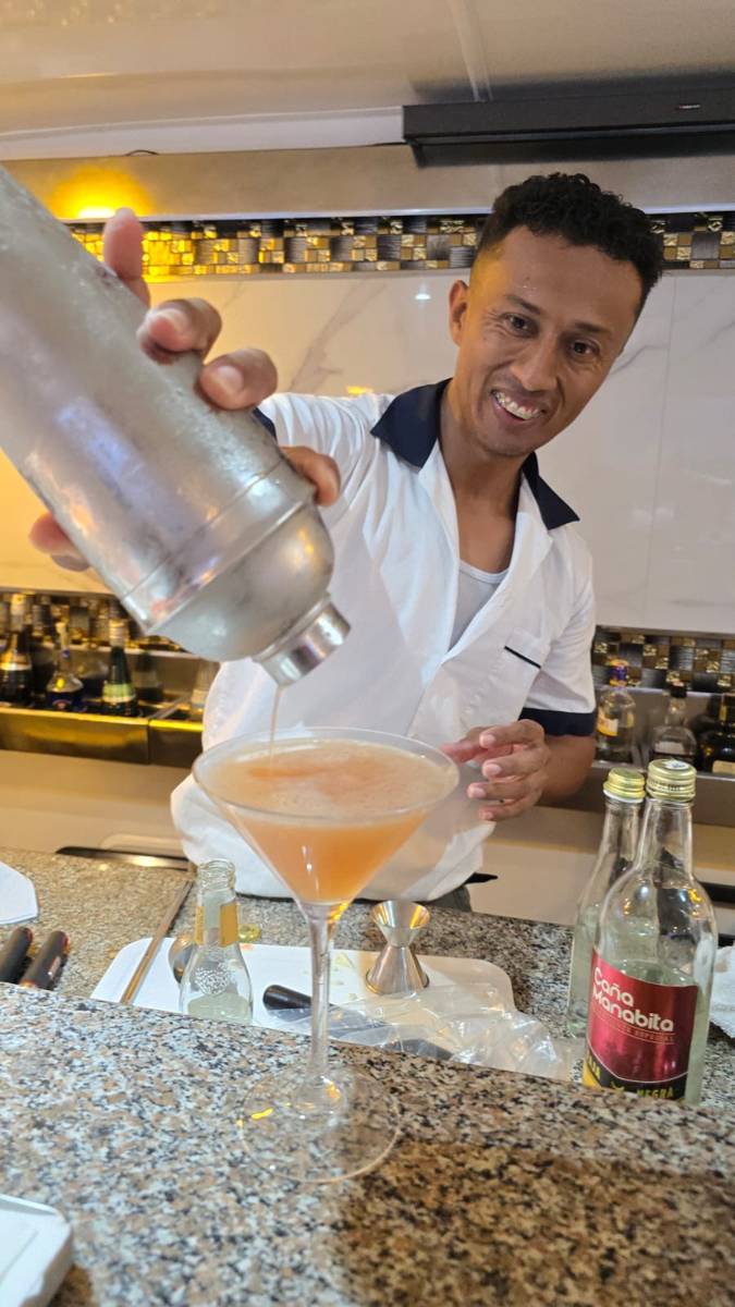 Bartender pouring a cocktail at the Yate Anahi bar aboard Cultured Travel's Galapagos cruise